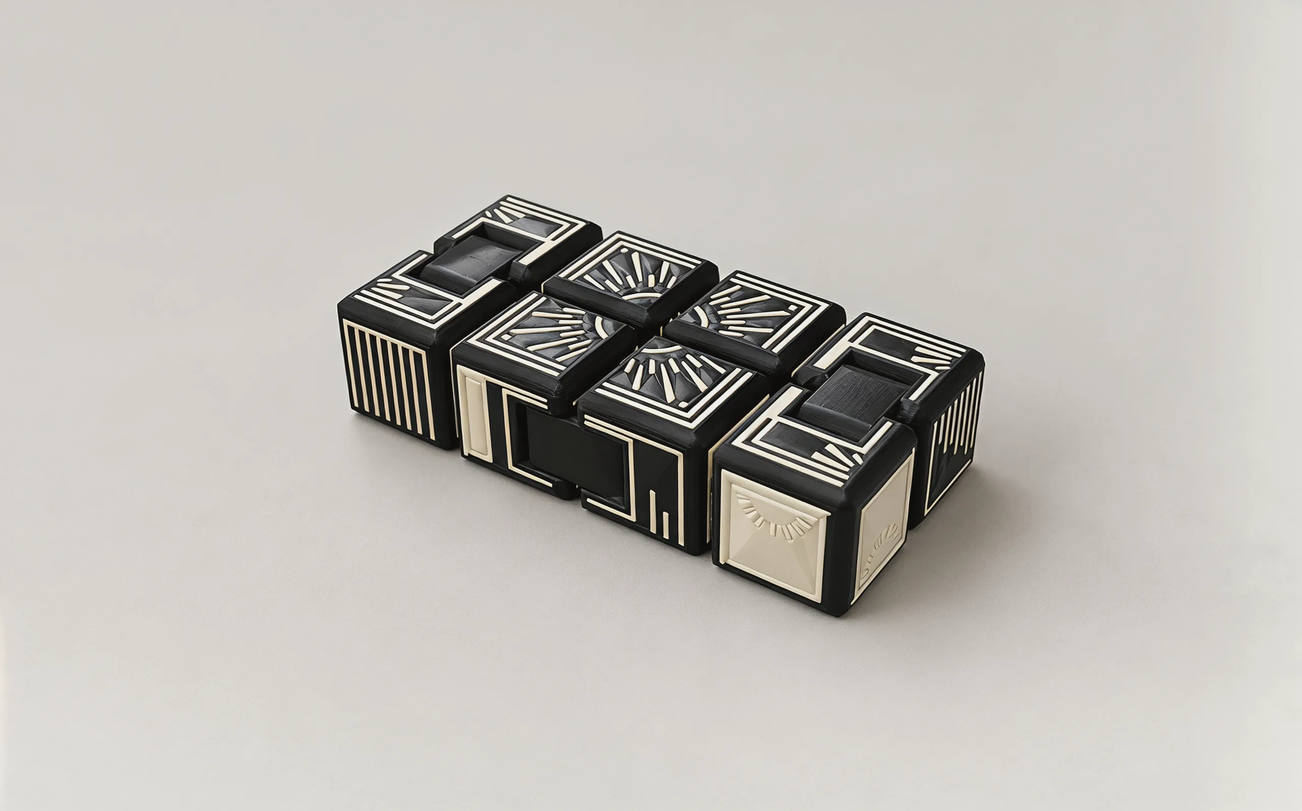 The cube lying flat on a pale ground, seen from a low angle: striped ends, framed tiles and the links set into the seams