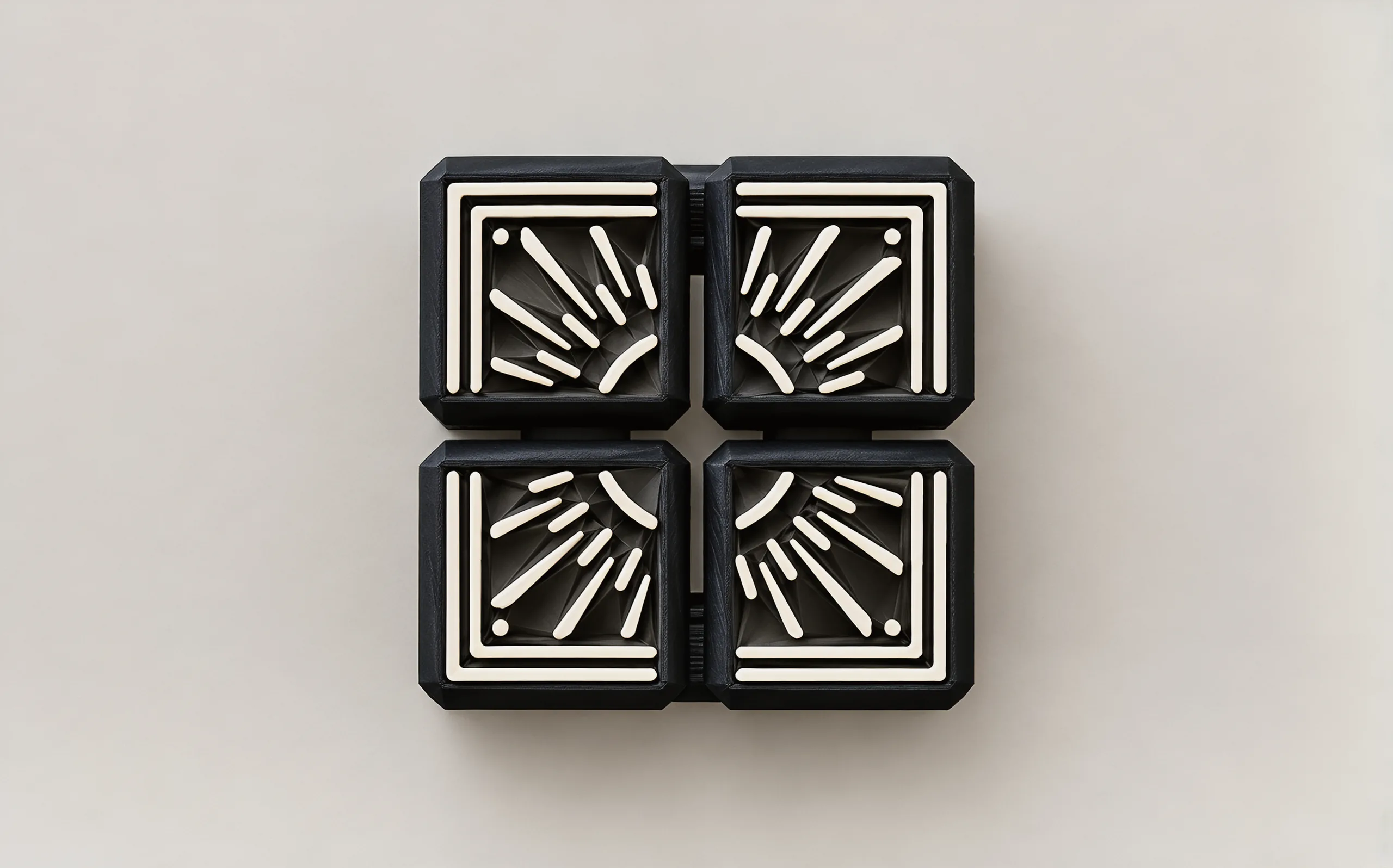Looking straight down on the sunburst face: four black tiles, each with ivory rays fanning from the centre and a stepped frame