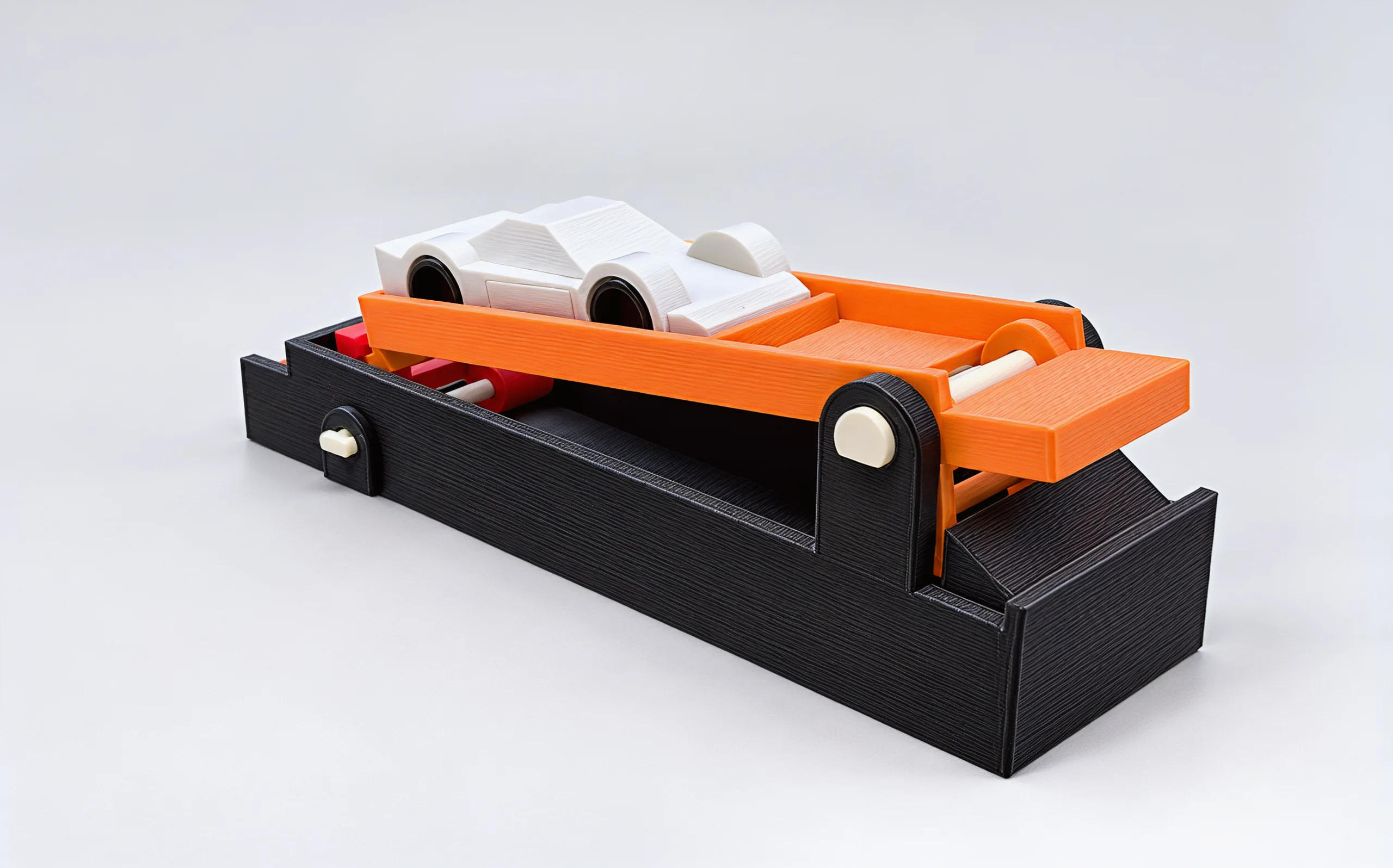 The launcher from the front corner: charcoal base, the orange paddle tilted up on its pale pivot pin, the silver car riding on top