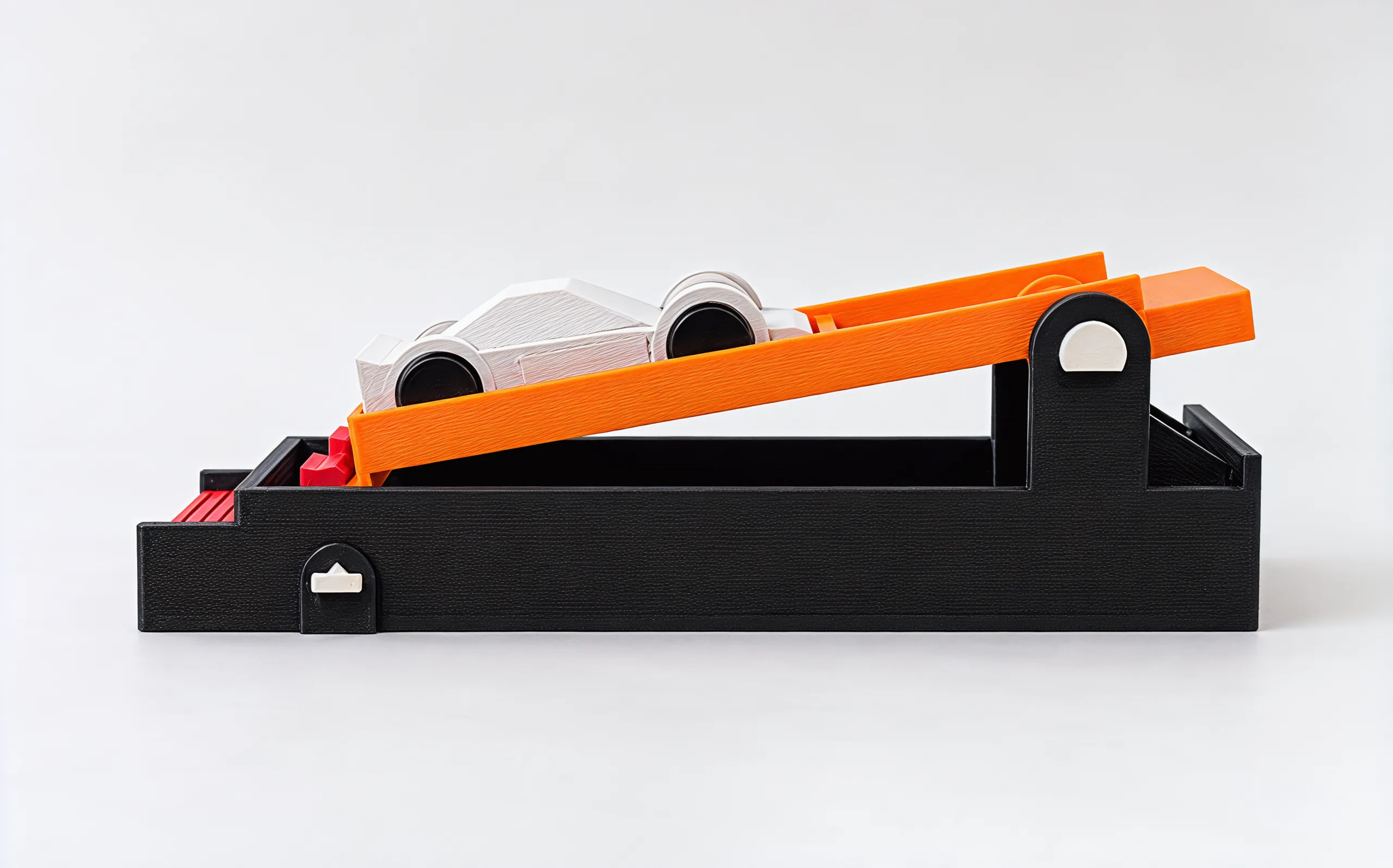 The launcher side on: the long charcoal base, the orange paddle rising toward its pivot post, the silver car on top