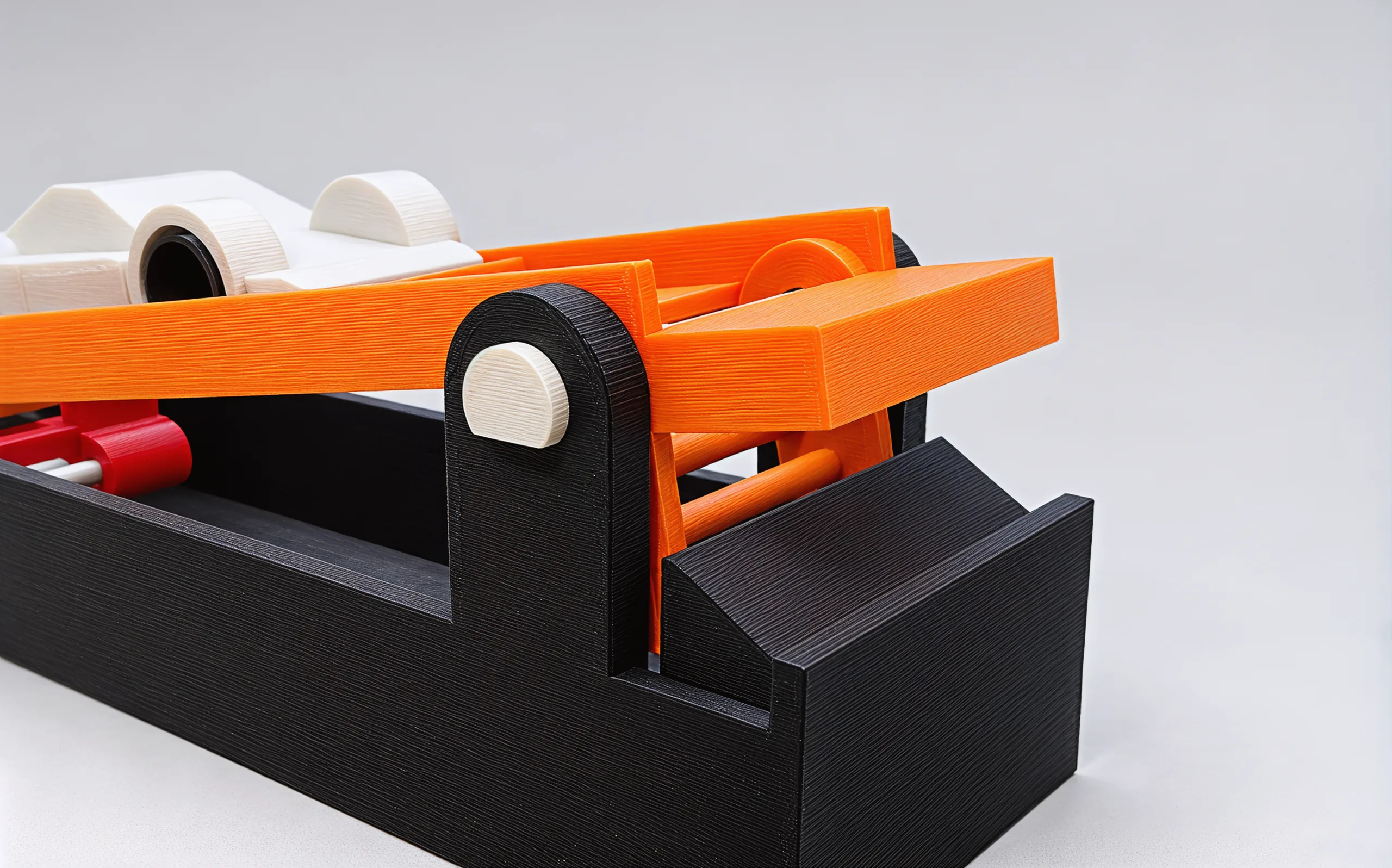 The front of the launcher: the paddle's pale pivot pin in a charcoal post, and the sloped stop in the base just ahead of it