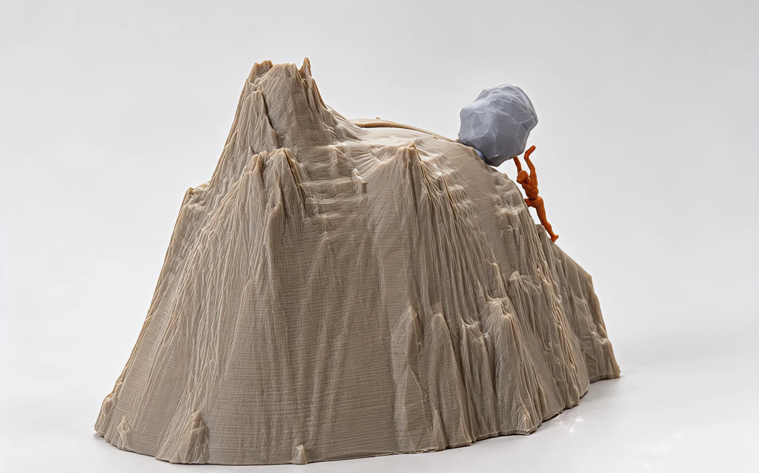 From behind: the crag peak in front, ledges and cliff lines down its face, the boulder and its climber small on the far slope