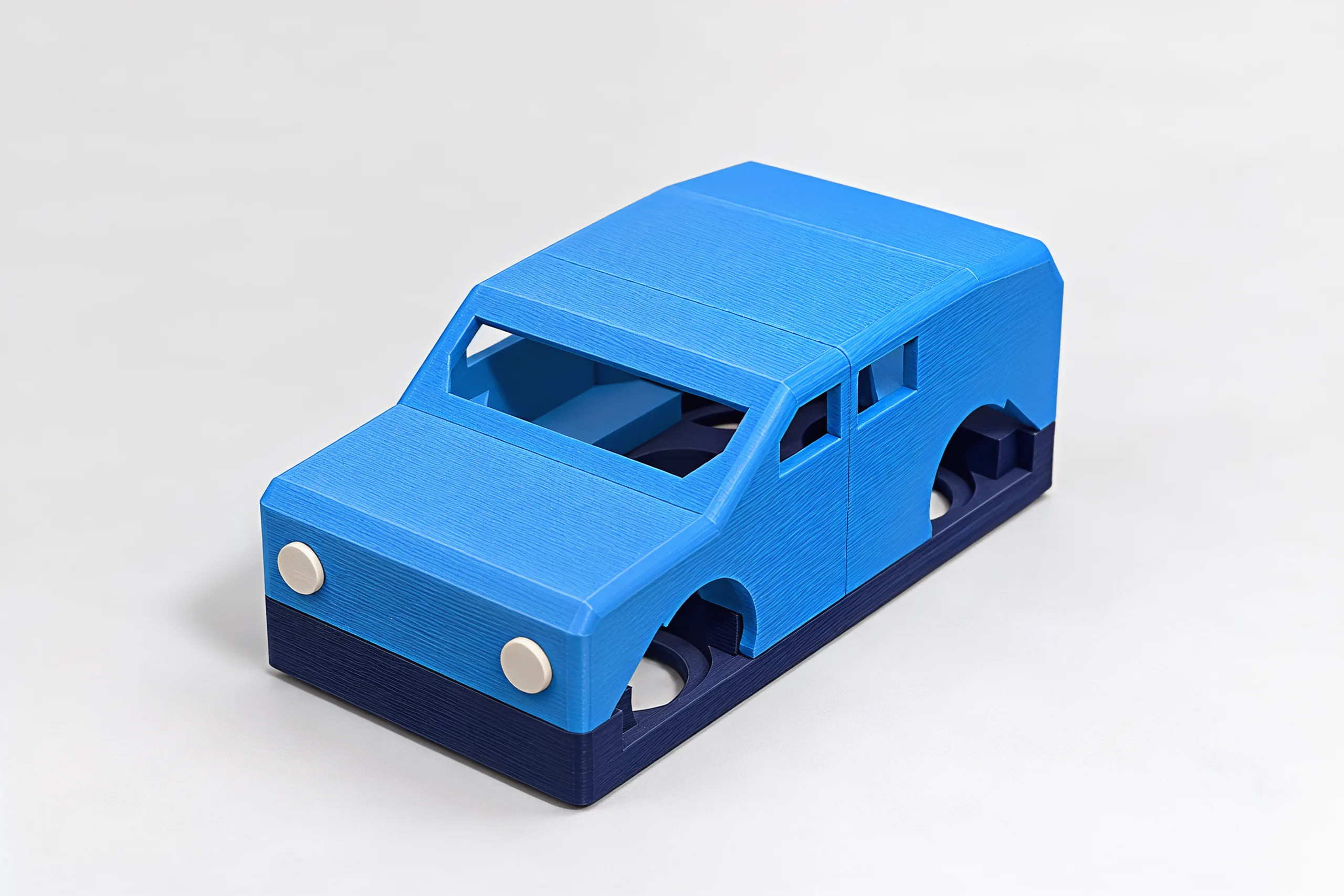 The blue hatchback from the front: two round cream headlights, an open windscreen, navy chassis showing through the wheel arches