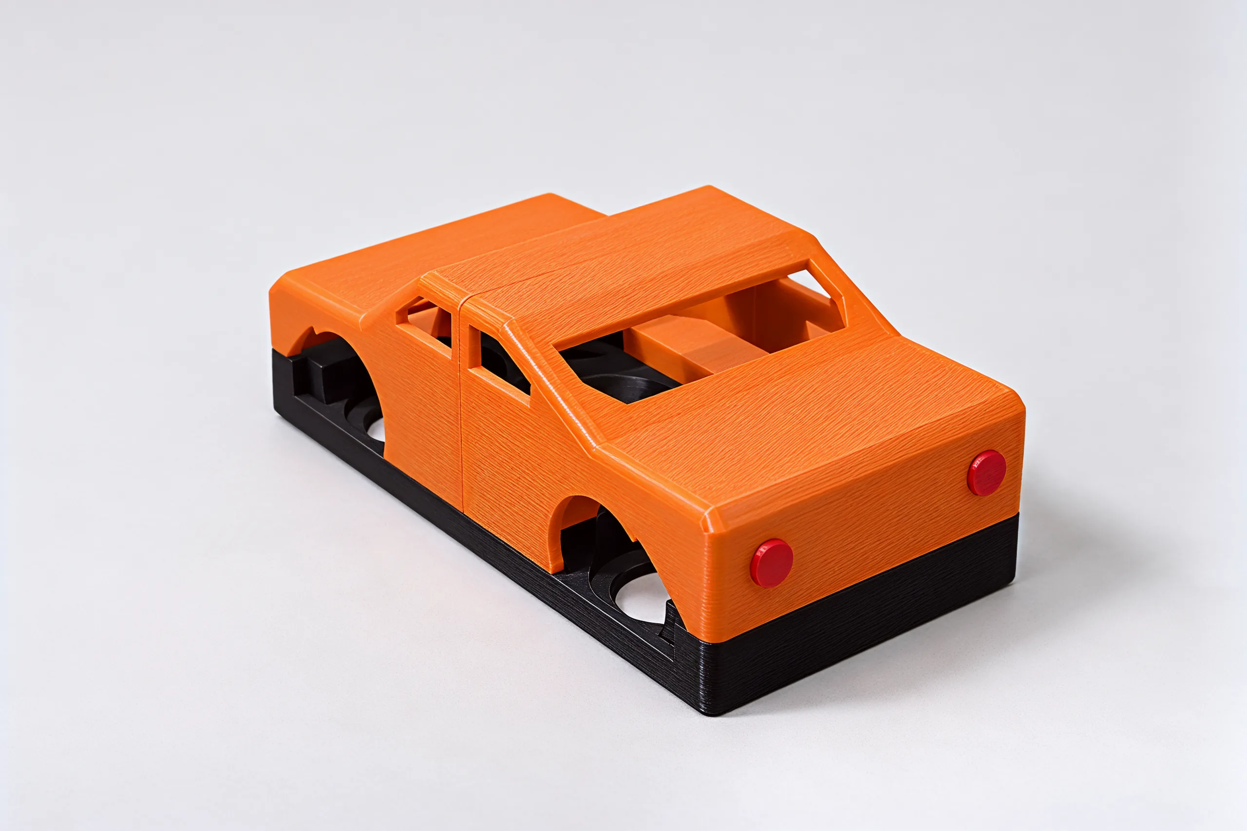 The orange sports coupe from behind: two red tail-lights, the seam at the doors, black chassis below