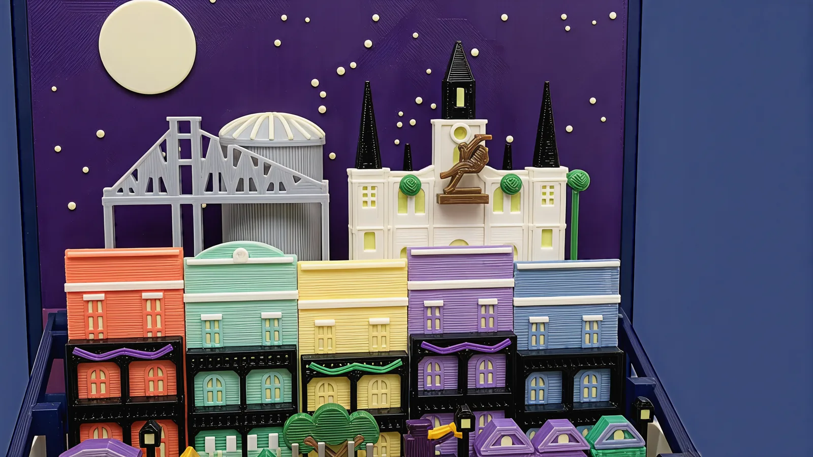 The back row against the purple sky panel and cream moon: the pale grey bridge truss, the ribbed dome, and the white cathedral with three black spires and a bronze rider between round trees