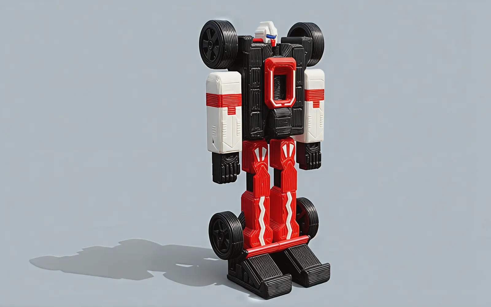 The robot from its left, fists hanging at its sides and a rear wheel beside each boot.