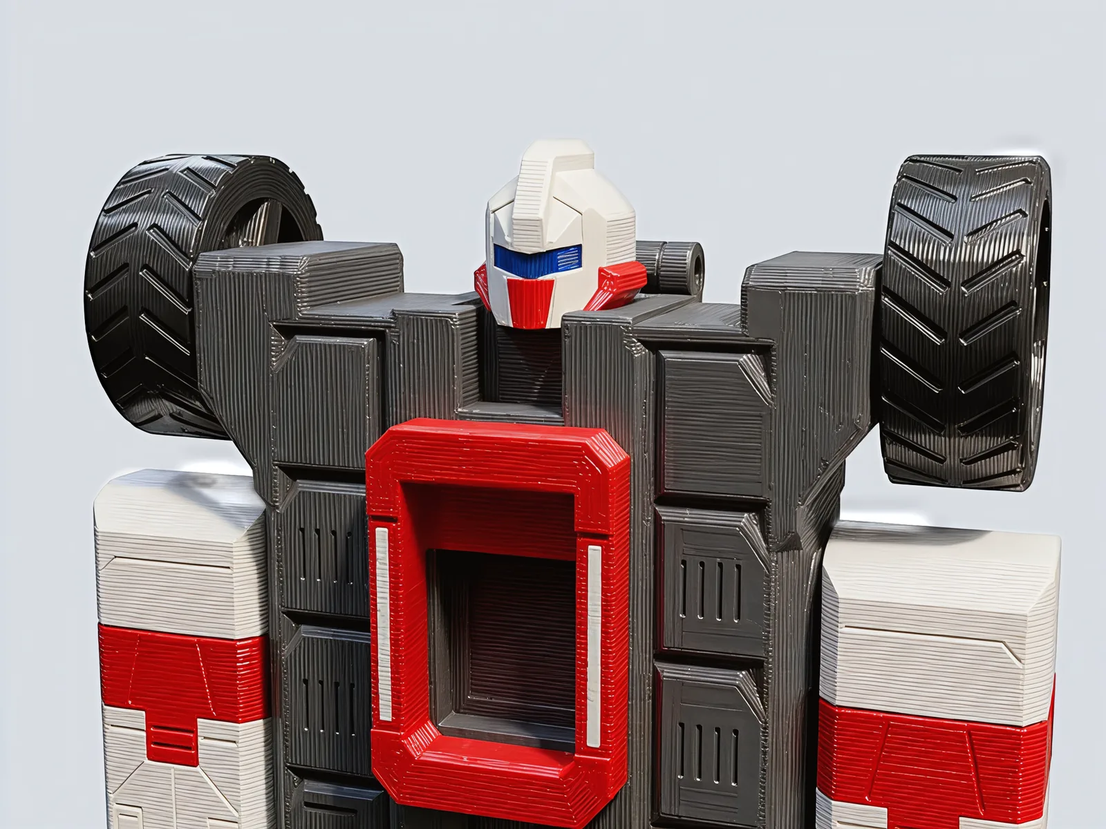 Close view of the robot's head between two treaded shoulder wheels, a blue visor over a red mouth plate, above the red halo on its chest.