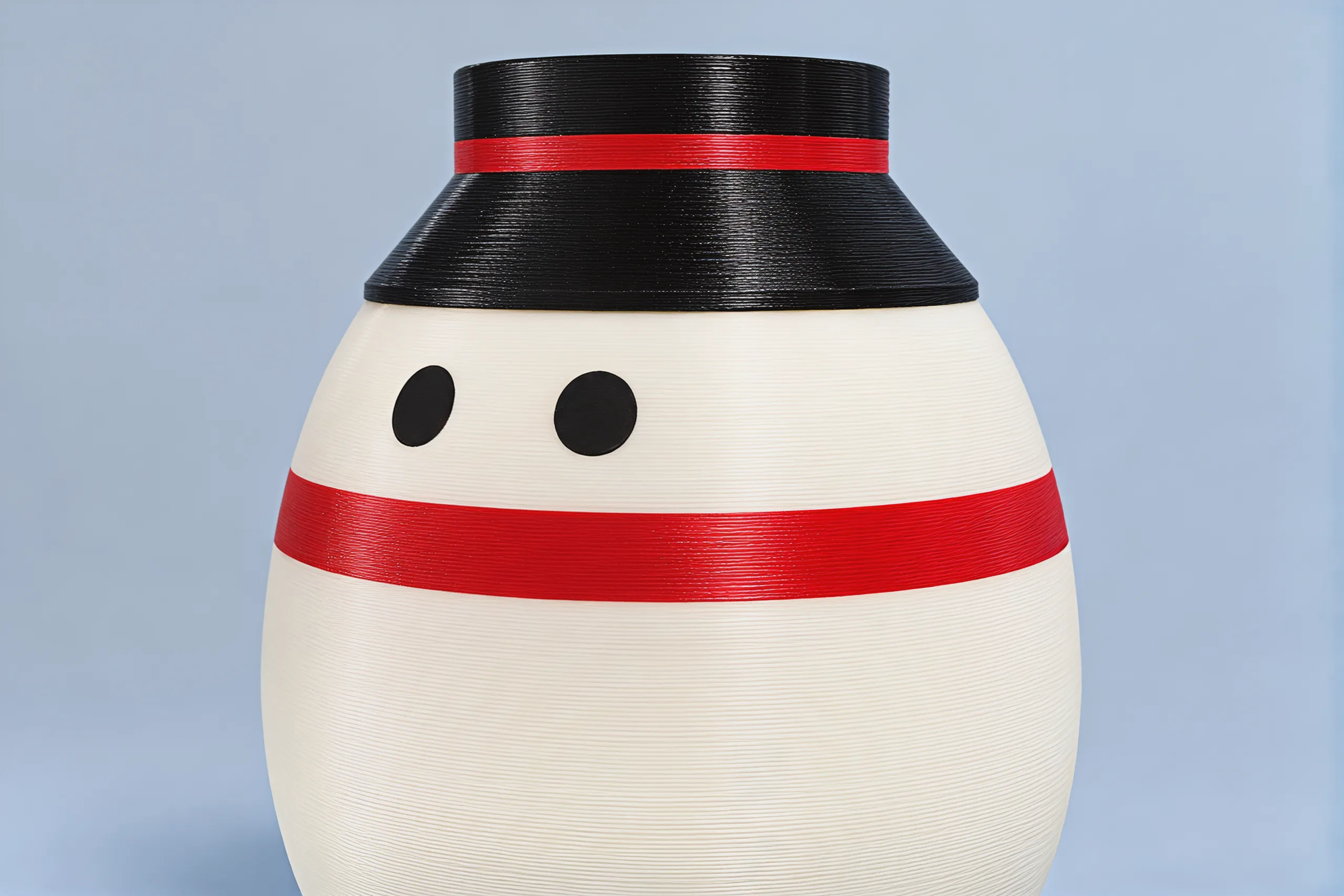 Close photo of his face: two round black eyes above a red scarf, fine ridges running round the white body