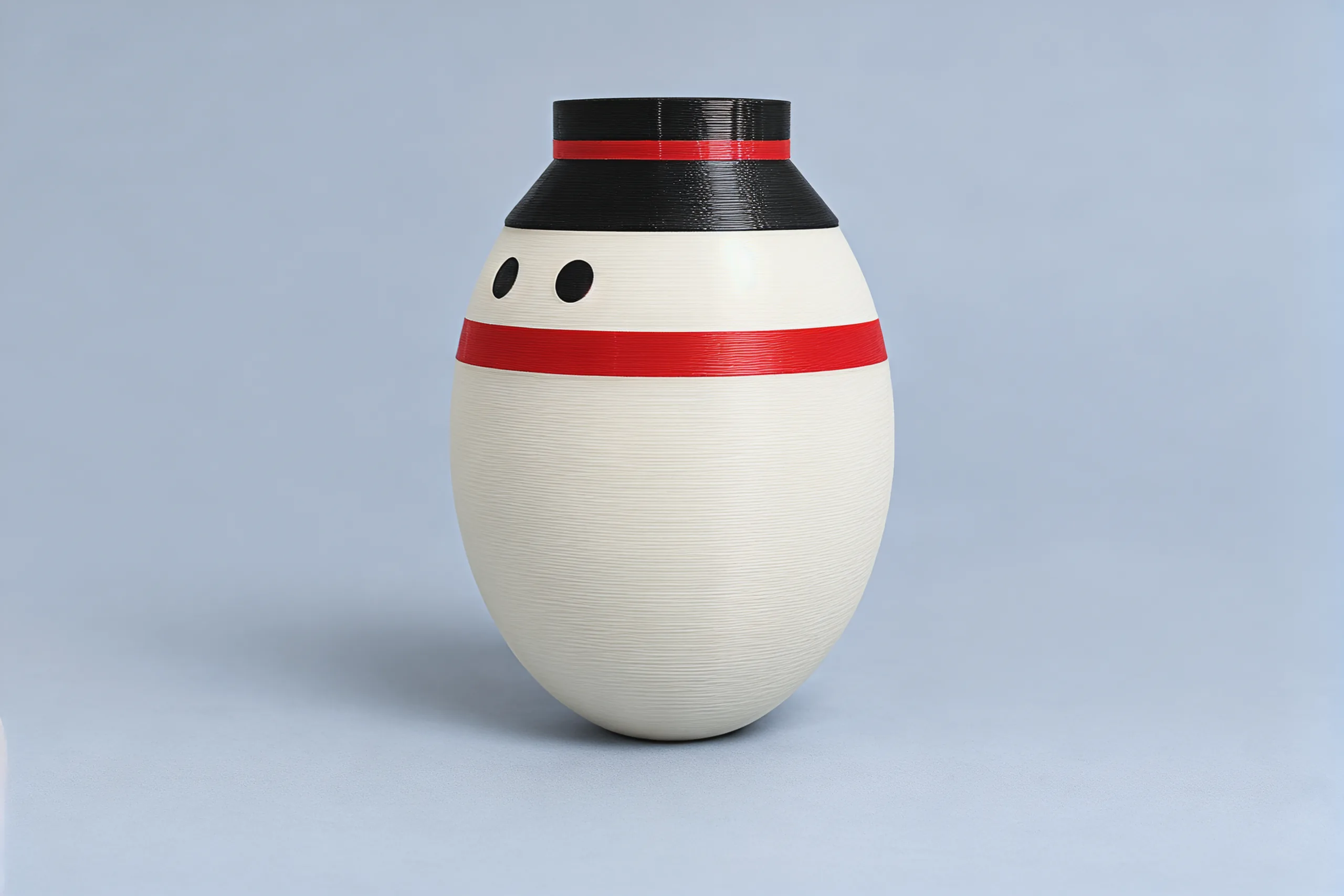 Studio photo of the snowman upright: white egg body, black top hat with a red band, two black eyes, a red scarf
