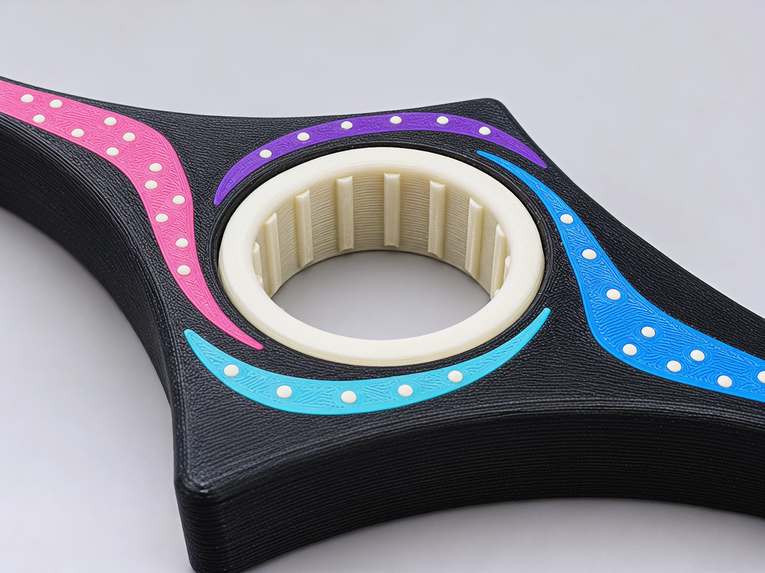 Close view of the cream ring and the arms around it; ridges run down the inside of the ring