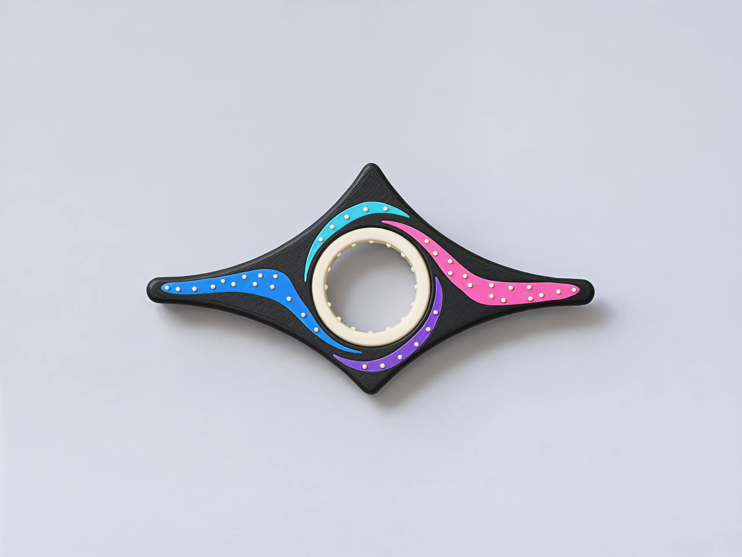 Straight down on the holder: a black four-pointed star with pink, lilac, sky blue and ice blue arms swirling round the cream ring, white stars dotted along them